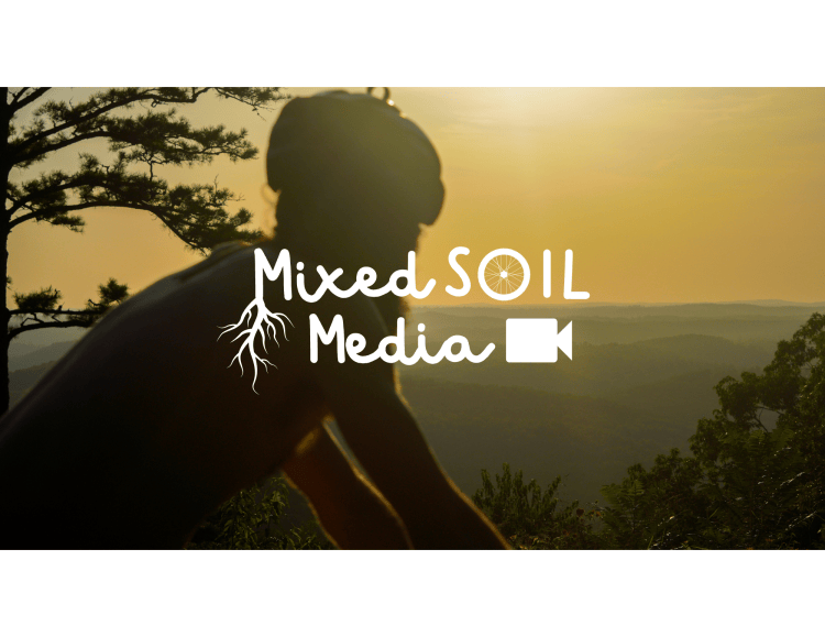 Documentary-style event photography by Mixed Soil Media cyclist riding at golden hour above current river valley with white logo overlayed
